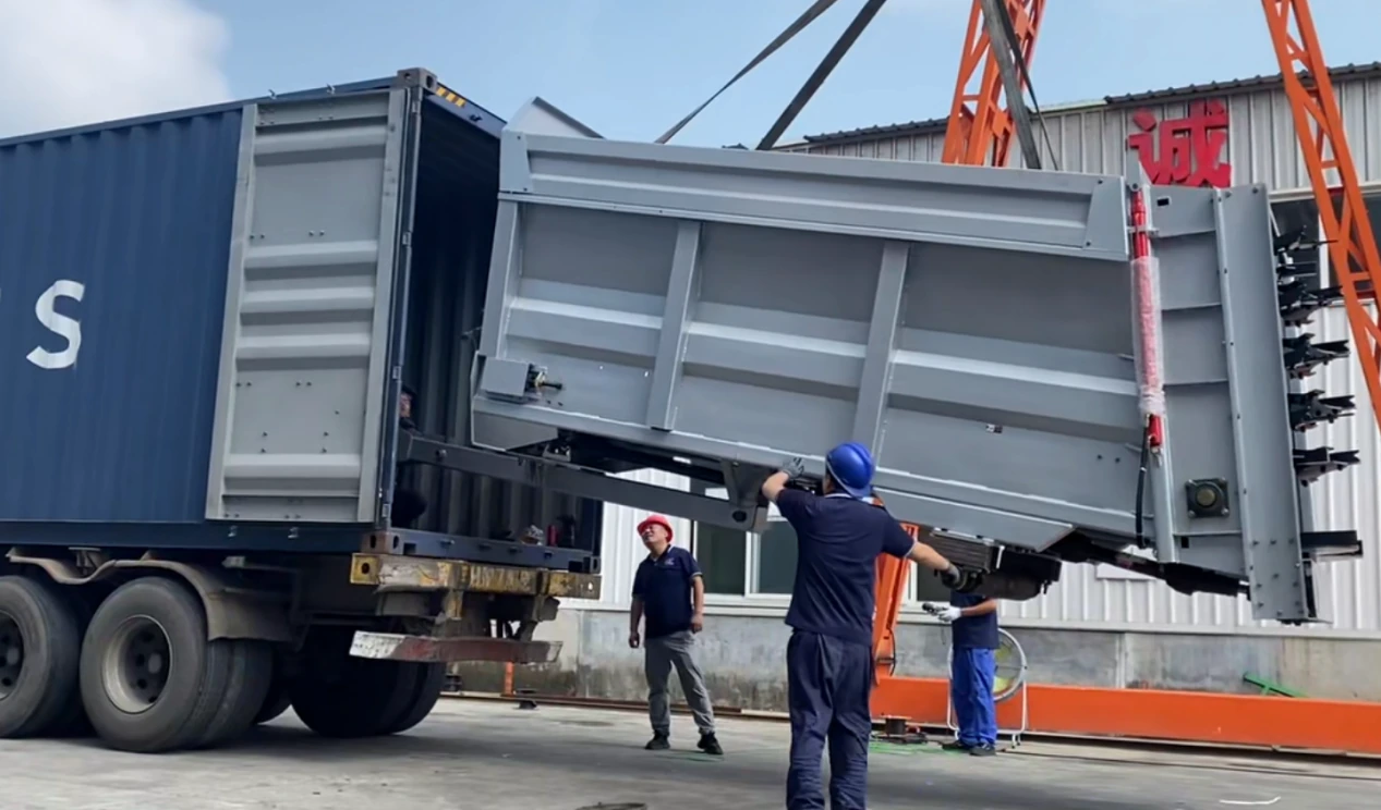 Custom manure spreader being loaded into a shipping container for Réunion